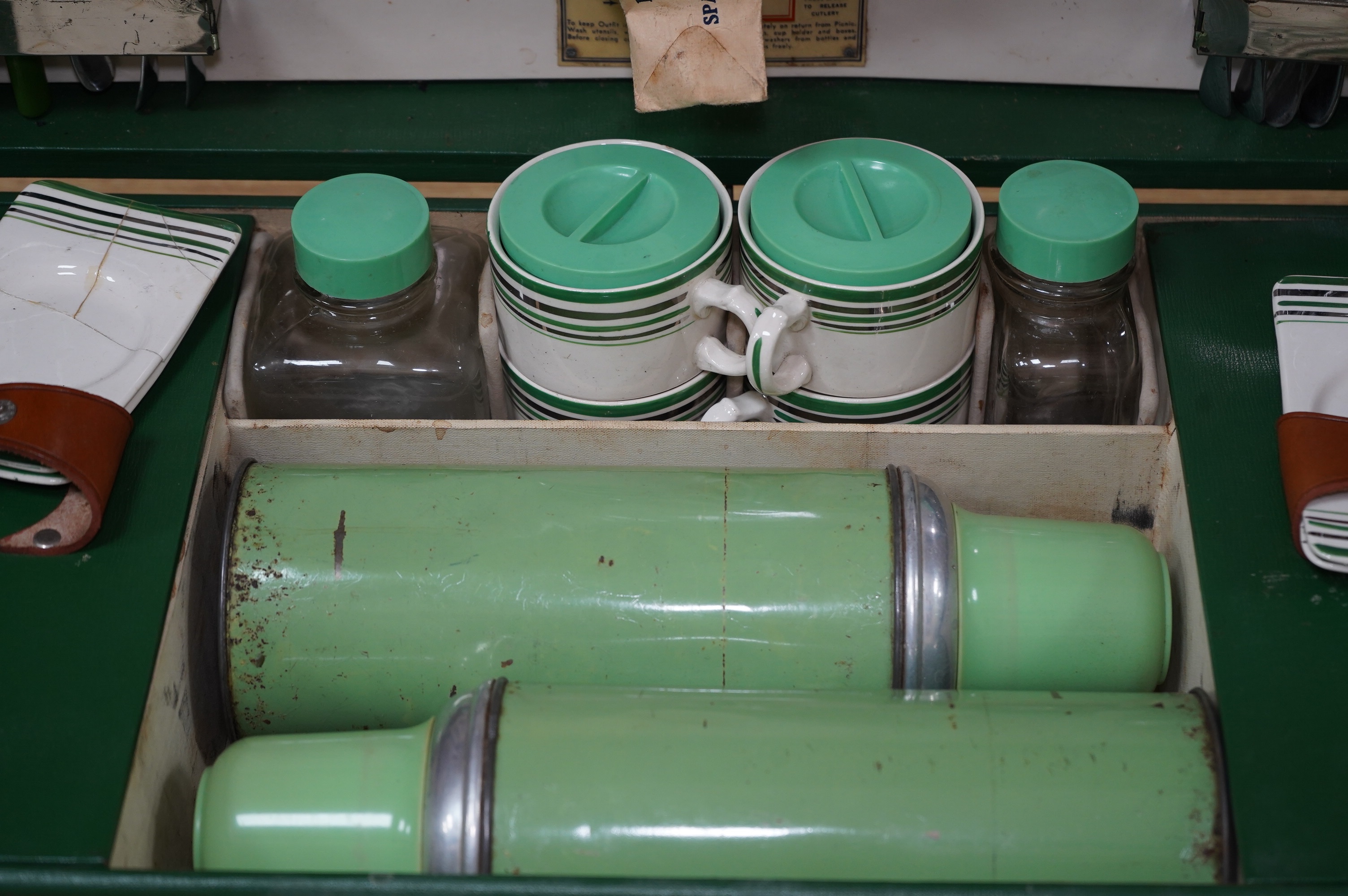 An Art Deco, c.1930's cased picnic set with flasks, cutlery, plates and cups. Condition - poor